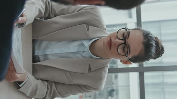 Vertical Shot of Female Lawyer Consulting Client about Contract