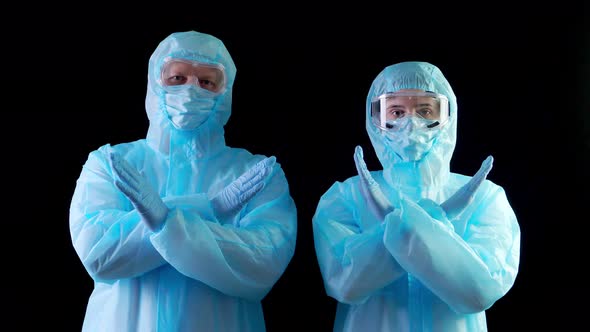 Doctor, Nurse, in Protective Uniforms, Masks, Goggles, Looking at Camera, Showing Stop Gesture By