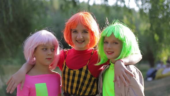 Teenage Girl Hugs Them Dressed in Colorful Wigs