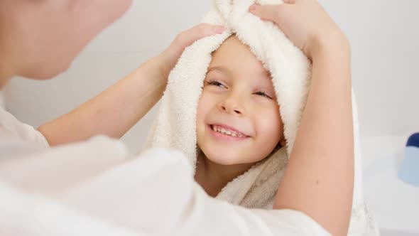 Portrait of Cute Smiling Boy with Wet Hair Wiping and Drying with Soft Towel After Having Bath and