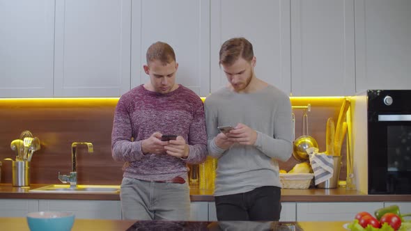 Gay Partners Browsing Online on Phones at Home