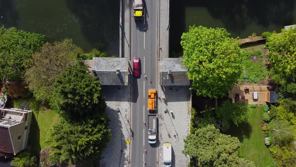 Highway maintenance and repair vehicles are set up ready to work on an old bridge coned off for traf