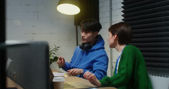 A Young Man and Woman Talking During the Working Day Sitting at the Same Table