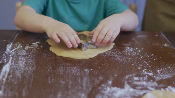 Little Child Hands Cutting Star Shape Cookie From Dough Pastry with Steel Cutter