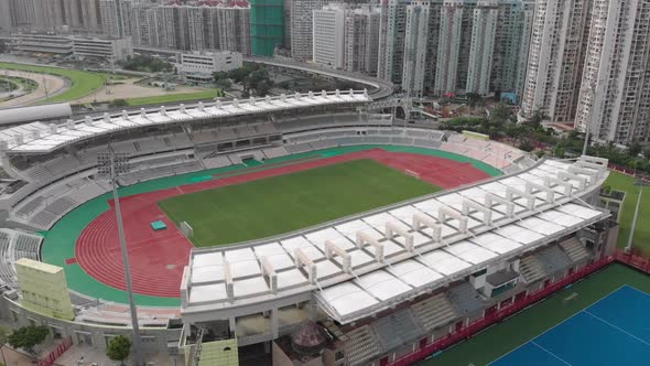 Rising tilt drone shot of the football pitch and athletics track at Macau Stadium