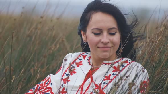 Portrait of Cheerful Charming Young Ukrainian Woman in National Clothes in Field