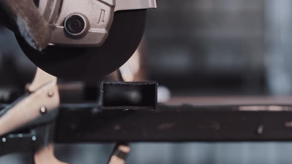 Manufacturing Plant Man Worker Cutting the Part of Metal Detail with Angle Saw Bright Flying