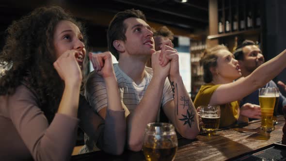 Cheering friends of soccer fans in the pub. Shot with RED helium camera in 8K.  