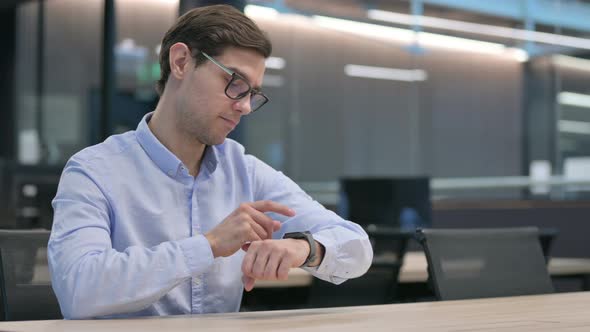 Young Man Feeling Curious While Using Smart Watch