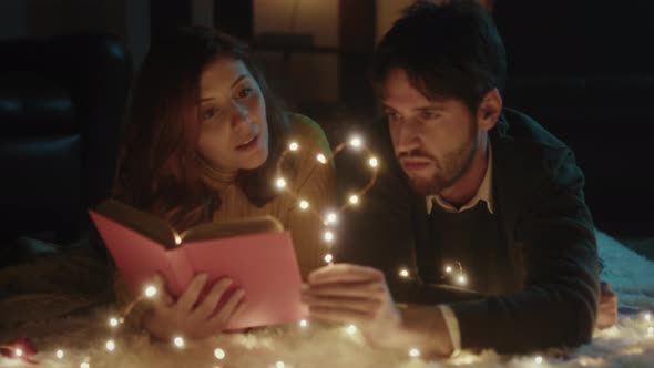 Couple reads book with valentine heart