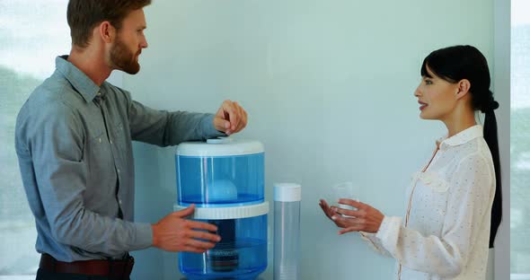 Colleagues interacting while drinking water