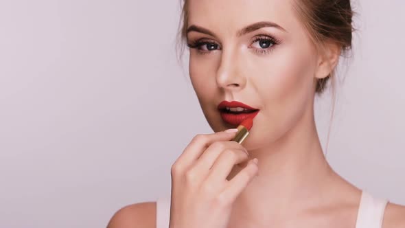 Beautiful Woman Applies Red Lipstick and Showing Heart with It