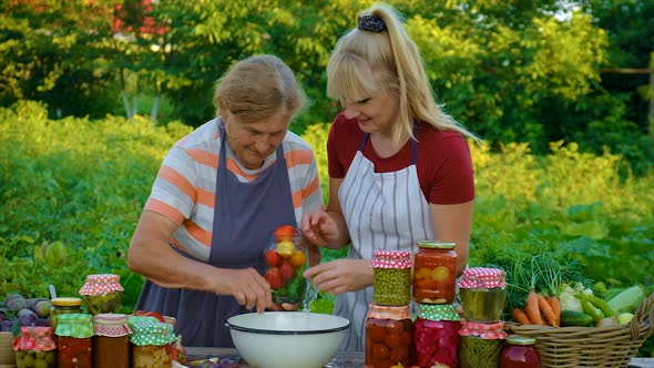 Women with Jar Preserved Vegetables for the Winter Mother and Daughter