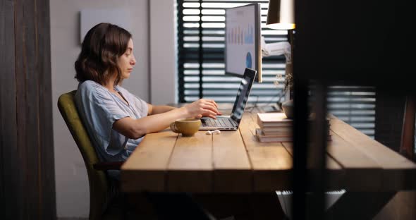 Woman Works on a Laptop at Cozy Home Office