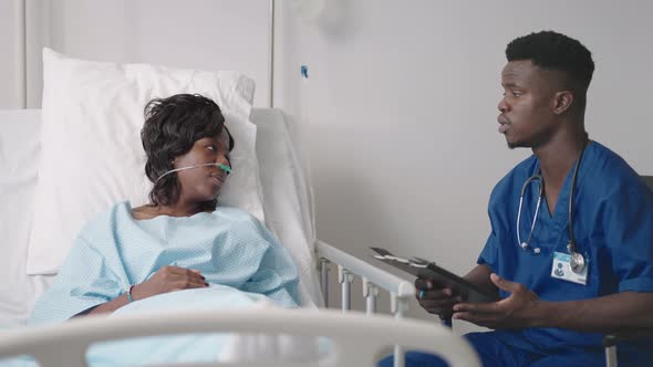 A Young AfricanAmerican Male Doctor is Talking to a Patient