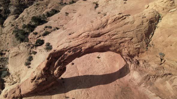 Aerial drone views as the camera tilts around Corona Arch, west of Moab, Utah.