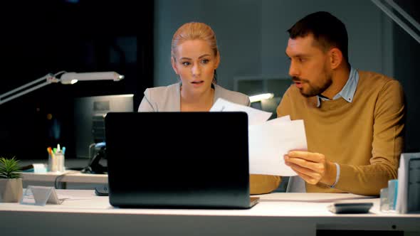 Business Team with Laptop and Files at Dark Office 13