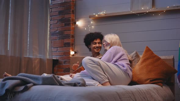 A Young LGBT Couple Lies in Bed in the Evening and Plays the Ukulele