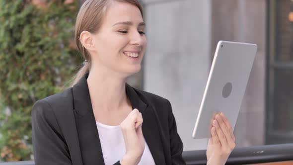 Video Chat on Tablet by Young Businesswoman Sitting Outdoor