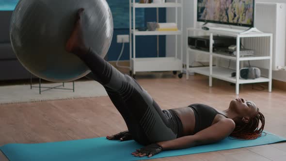 Athletic Slim Black Woman Pumps Abdominal Muscle Press Laying on Floor