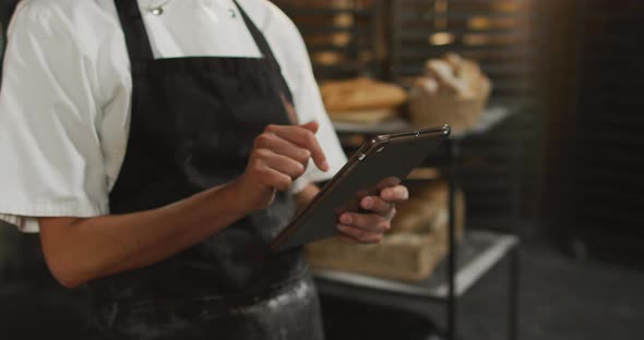 Animation of hands of asian female baker using tablet