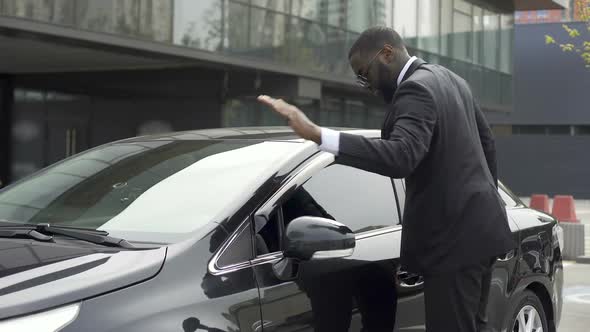 Scrupulous Afro-American Man Wiping His New Car Before Leaving Parking Lot