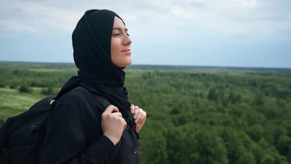 Smiling Muslim Backpacker Female Admiring Nature Landscape From Top of Mountain Travel Vacation