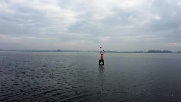 Flying with a drone towards a red light buoy.