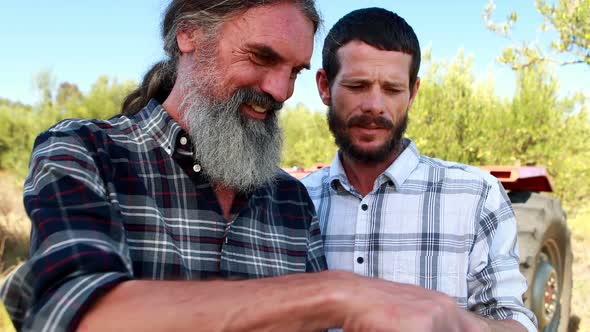 Friends discussing over laptop in farm 4k