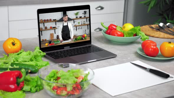 Laptop with Man Chef Blogger in Screen Tells Recipe of Dish Teaches Student