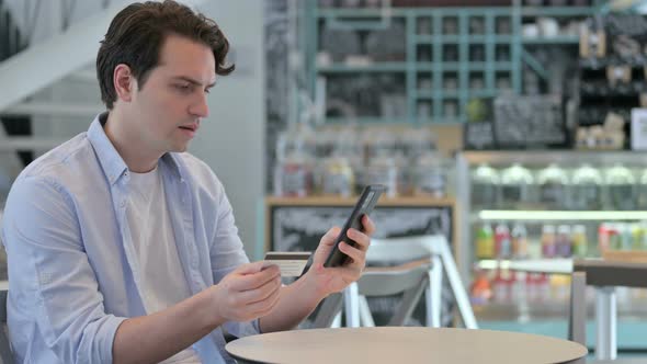 Young Man Making Successful Online Payment on Smartphone