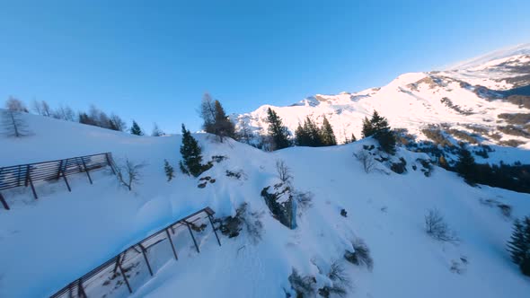 fpv drone showing two skiiers waiting on the ridge to drop a beautiful powder line in the austrian w