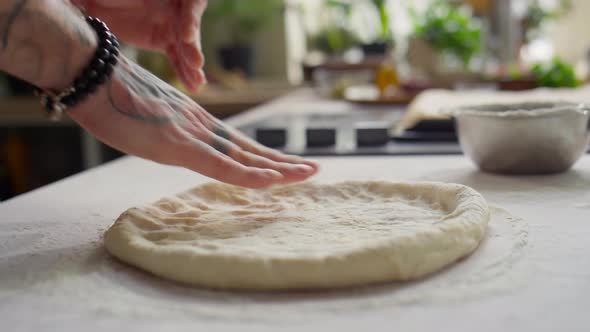 Hands Flattening Dough for Pizza