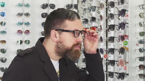 Bearded Man Trying on Glasses at the Eyewear Store