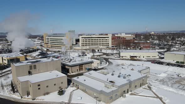 Aerial view of large building complex in the winter with a bright blue sky.