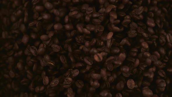 Coffee beans fly after being exploded. Slow Motion.