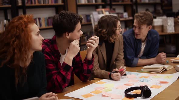 Four Young European Students Marketing Research Team Brainstorming Working on Startup Business Plan