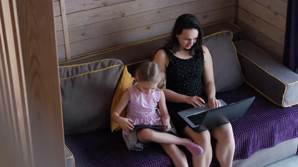 Mom Working Remotely While Child Uses Tablet PC