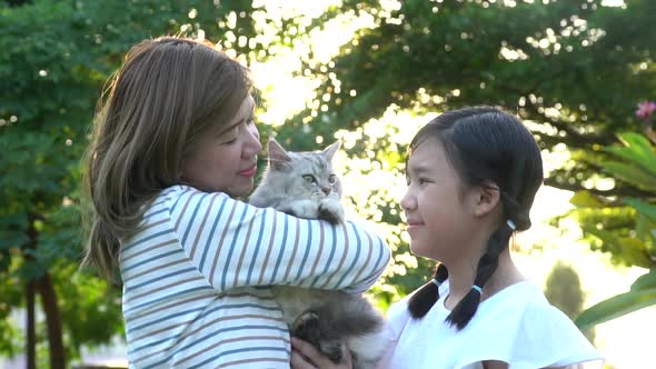 Asian Mother Playing A Kitten To Her Daughter 