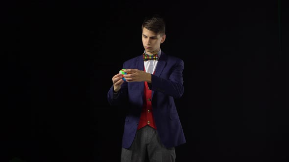 Brunette Man in Suit Is Solving Rubik's Cube in Dark.