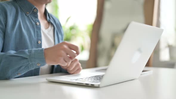 Close Up of Man Investing Dollars Through Laptop