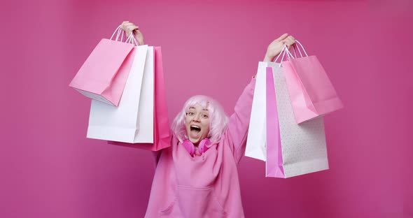 Happy Girl Enjoys After Shopping with Colorful Bags in Pink Colour Concept