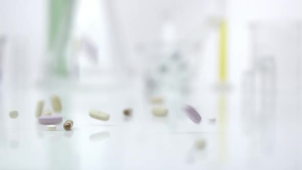 Panning view of pills dropping