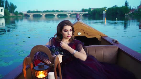 Elegant female with perfect make-up and beautiful dress riding a boat