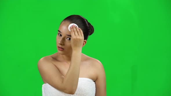 Woman with Bare Shoulders in White Towel Using Cotton Pad, Cleans Her Face