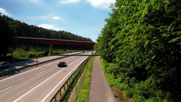 Cars Driving European Route E28 From Roadside With Green Trees In Gdynia, Poland. - aerial ascend