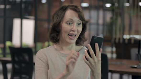 Excited Old Woman Using Cellphone and Celebrating Success