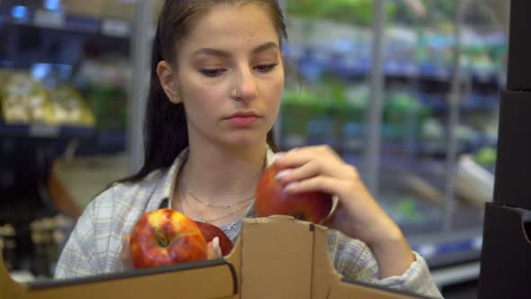 Woman Taking Apples From Box in Supermarket