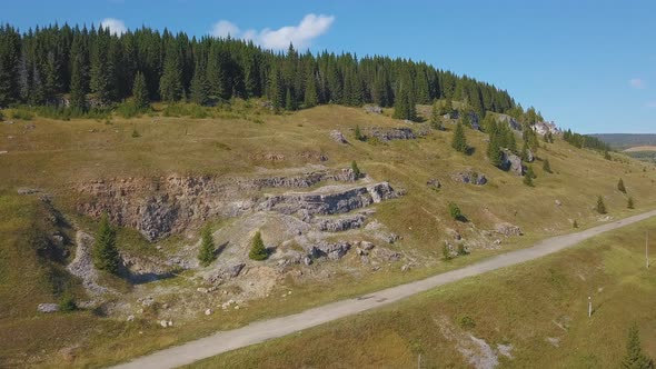 A green hilly mountain with roads