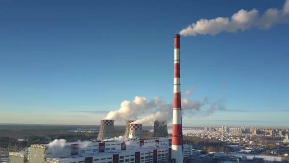 Upper View Plant with Cooling Towers and Chimney Against Sky